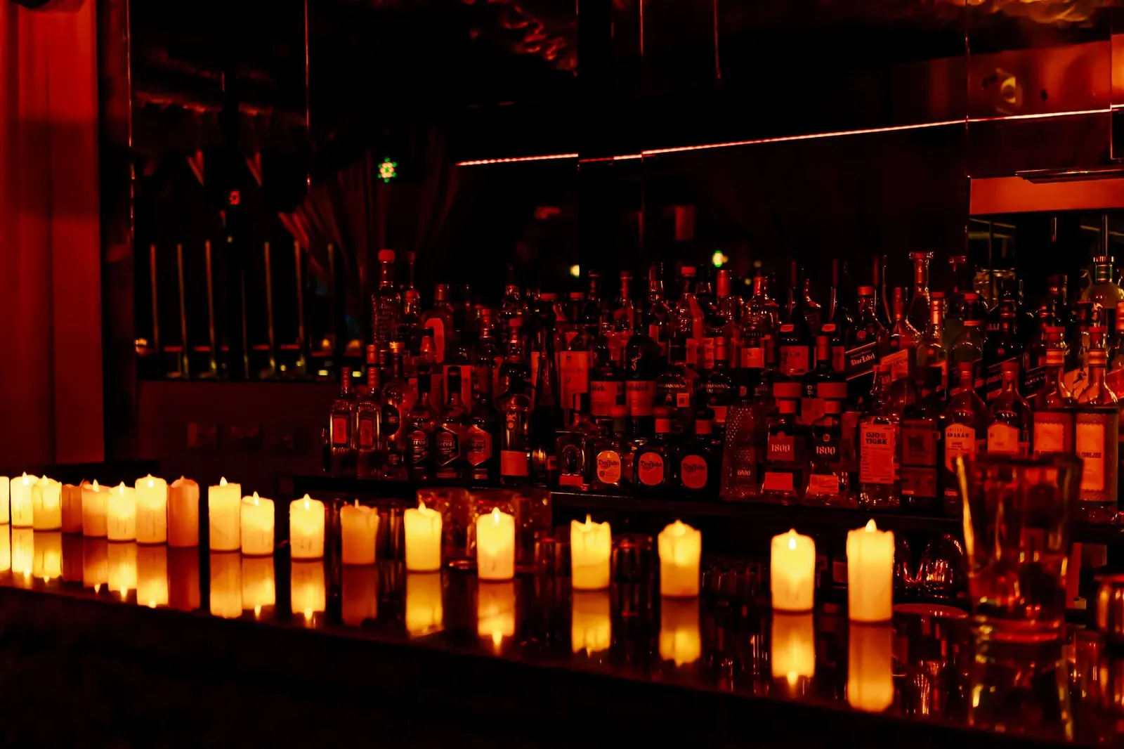 La barra de Nuberu con velas encendidas y destilados