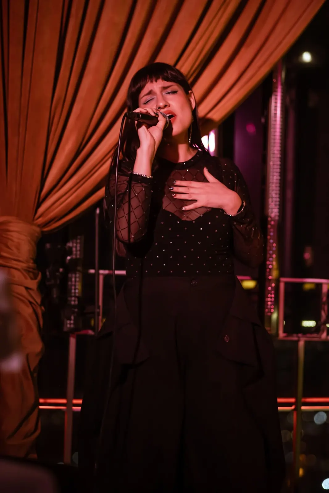 Cantante en vivo entre cortinas doradas
