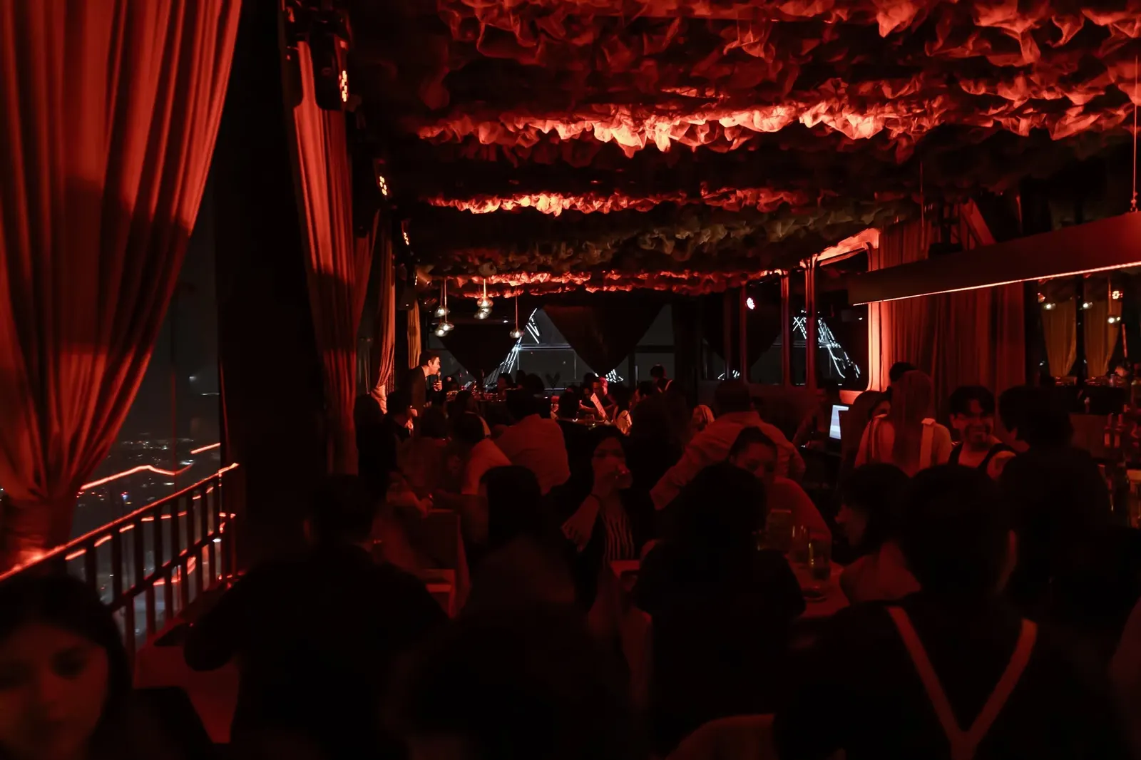 El salón de Nuberu en plena noche: techo de nubes iluminado, cortinas y música en vivo